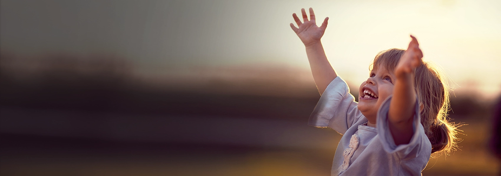 Child with arms up smiling